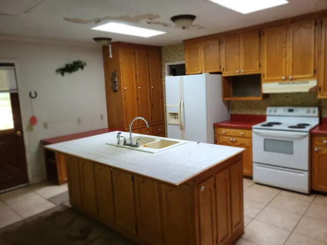 a kitchen with stainless steel appliances a stove a refrigerator and a sink