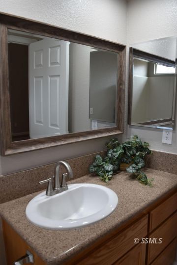 1405 Sims Street Ridgecrest, CA 93555 - Photo 12 of 12 a bathroom with a sink and a mirror