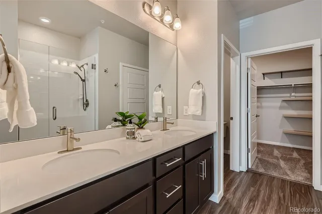 a bathroom with a double vanity sink mirror and shower
