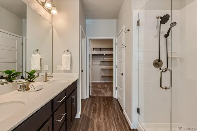 a bathroom with a double vanity sink a mirror and a shower