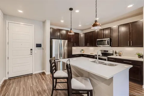a kitchen with kitchen island a sink appliances and cabinets