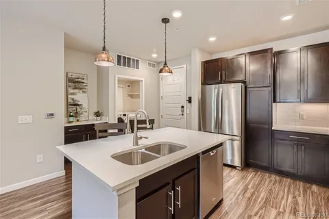 a kitchen with kitchen island a sink stove and refrigerator