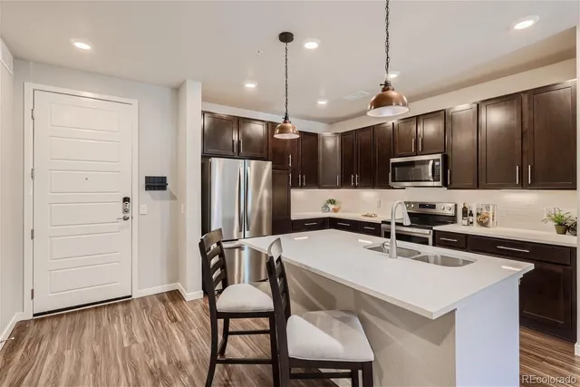 a kitchen with kitchen island a sink appliances and cabinets
