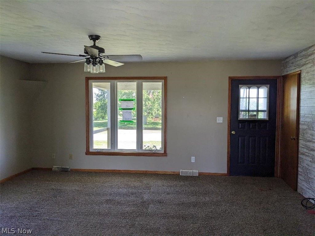 13096 Smith Road Wellington, OH 44090 - Photo 11 of 24 Living area featuring neutral wall paint, textured ceiling, and dark carpet flooring
