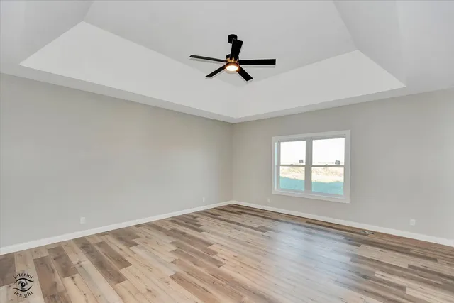 a view of a livingroom with a ceiling fan and wooden floor