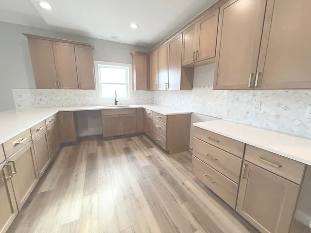 a view of a big room with wooden floor and windows