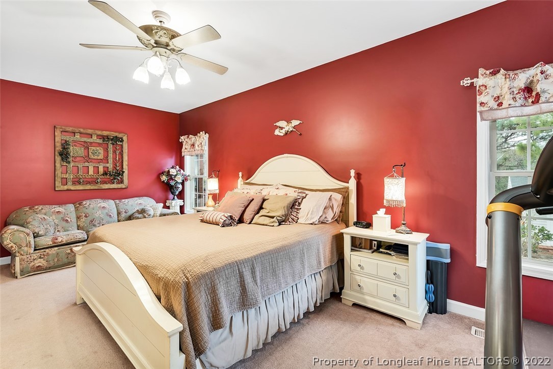 145 Covenant Road Carthage, NC 28327 - Photo 17 of 42 a bedroom with a bed and a chandelier