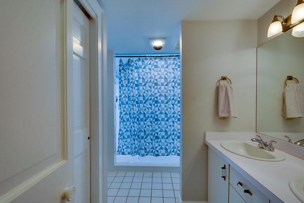 29 Sheridan Road Wellesley, MA 02481 - Photo 17 of 32 a bathroom with a sink a mirror and shower