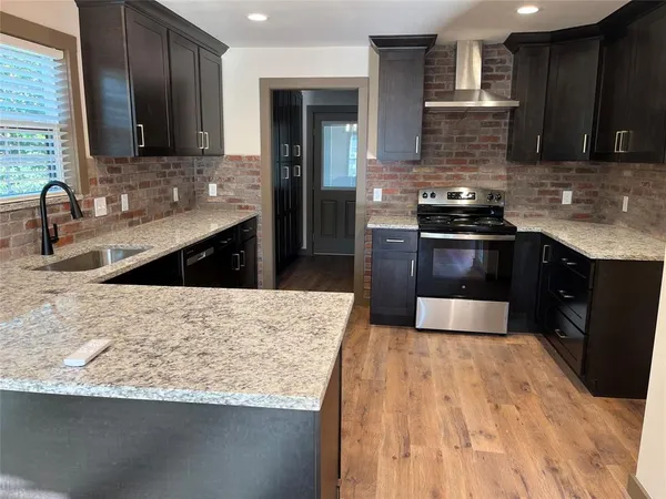 a kitchen with granite countertop wooden cabinets and stainless steel appliances