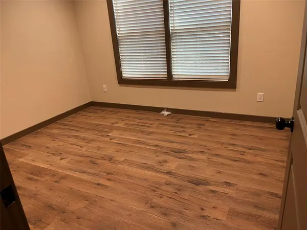 a view of a room with wooden floor and a window