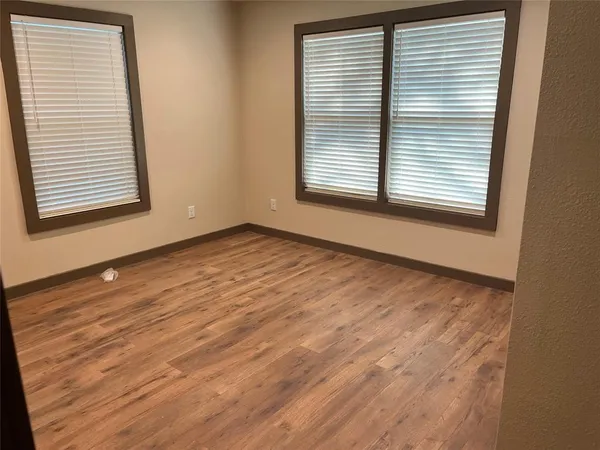 an empty room with wooden floor and a window