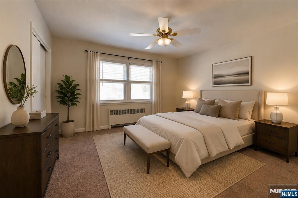 255 Bogert Road, Unit 2A River Edge, NJ 07661 - Photo 11 of 23 a bedroom with a bed and a chandelier