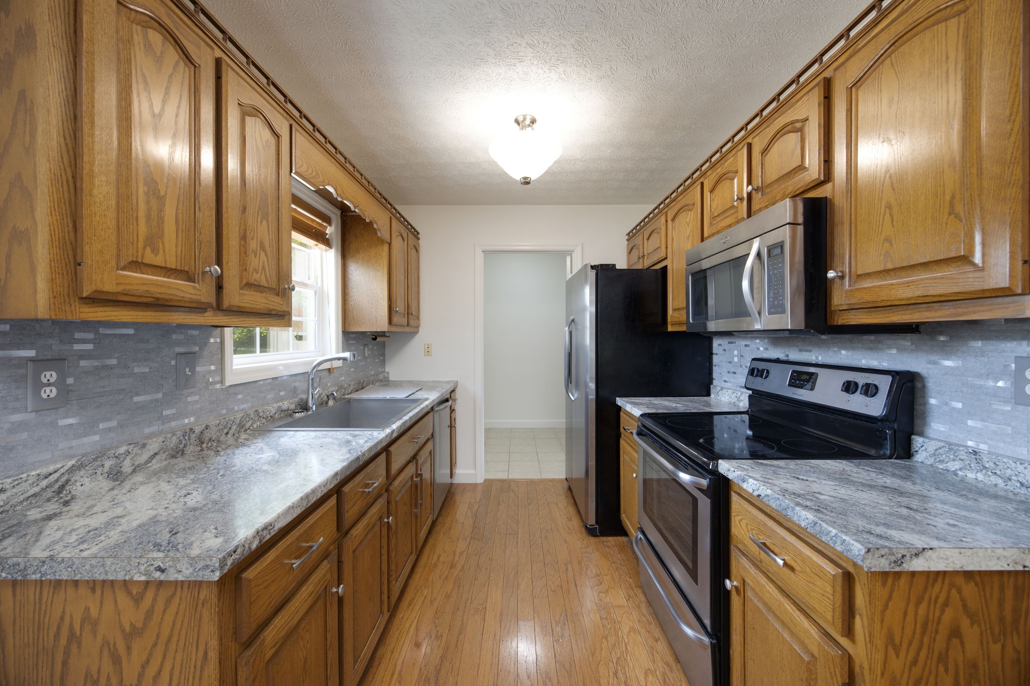 880 Denning Ford Road Portland, TN 37148 - Photo 10 of 54 a kitchen with stainless steel appliances granite countertop a sink a stove and a wooden cabinets