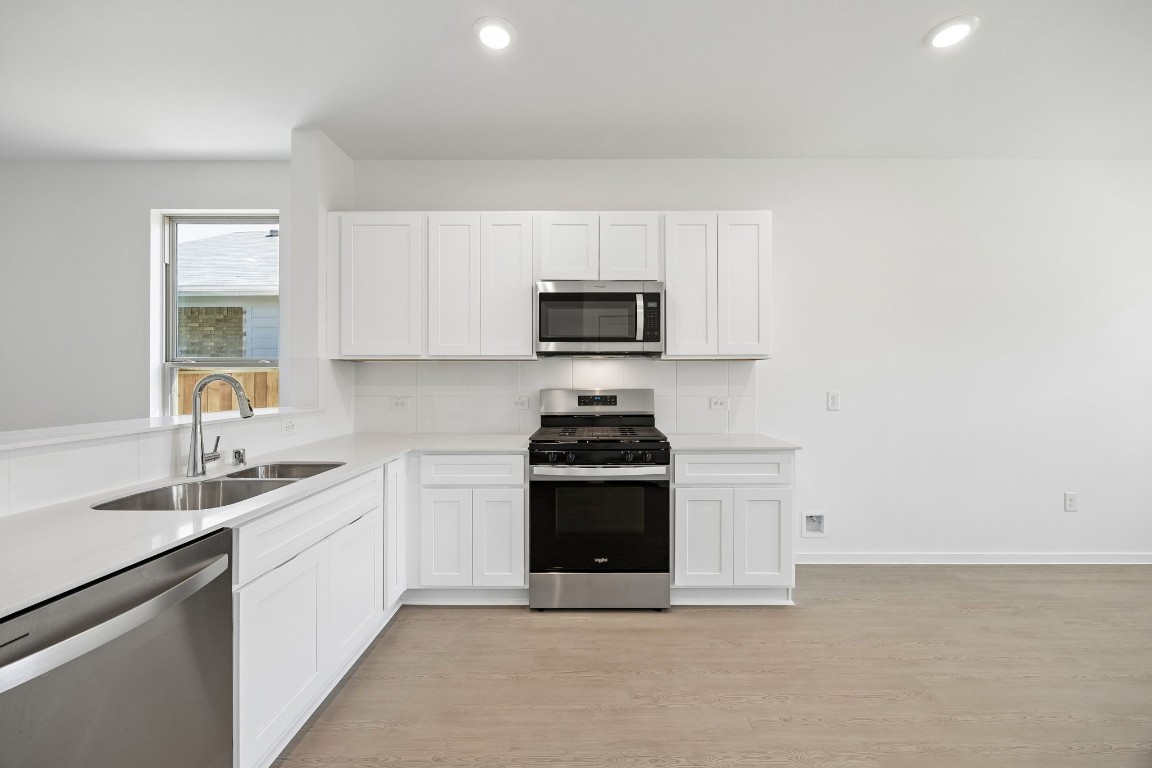 15023 Rustic Moon Road Conroe, TX 77302 - Photo 24 of 32 a kitchen with stainless steel appliances granite countertop a stove a sink and a microwave