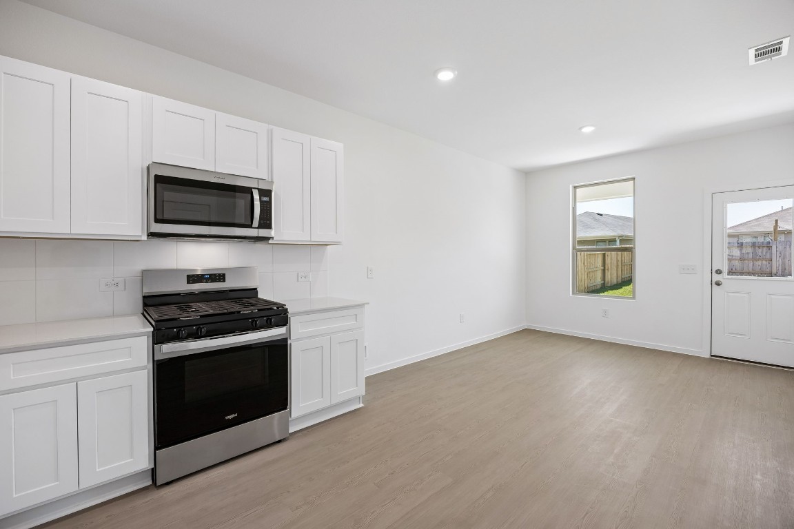 15023 Rustic Moon Road Conroe, TX 77302 - Photo 7 of 32 a kitchen with a stove and a microwave