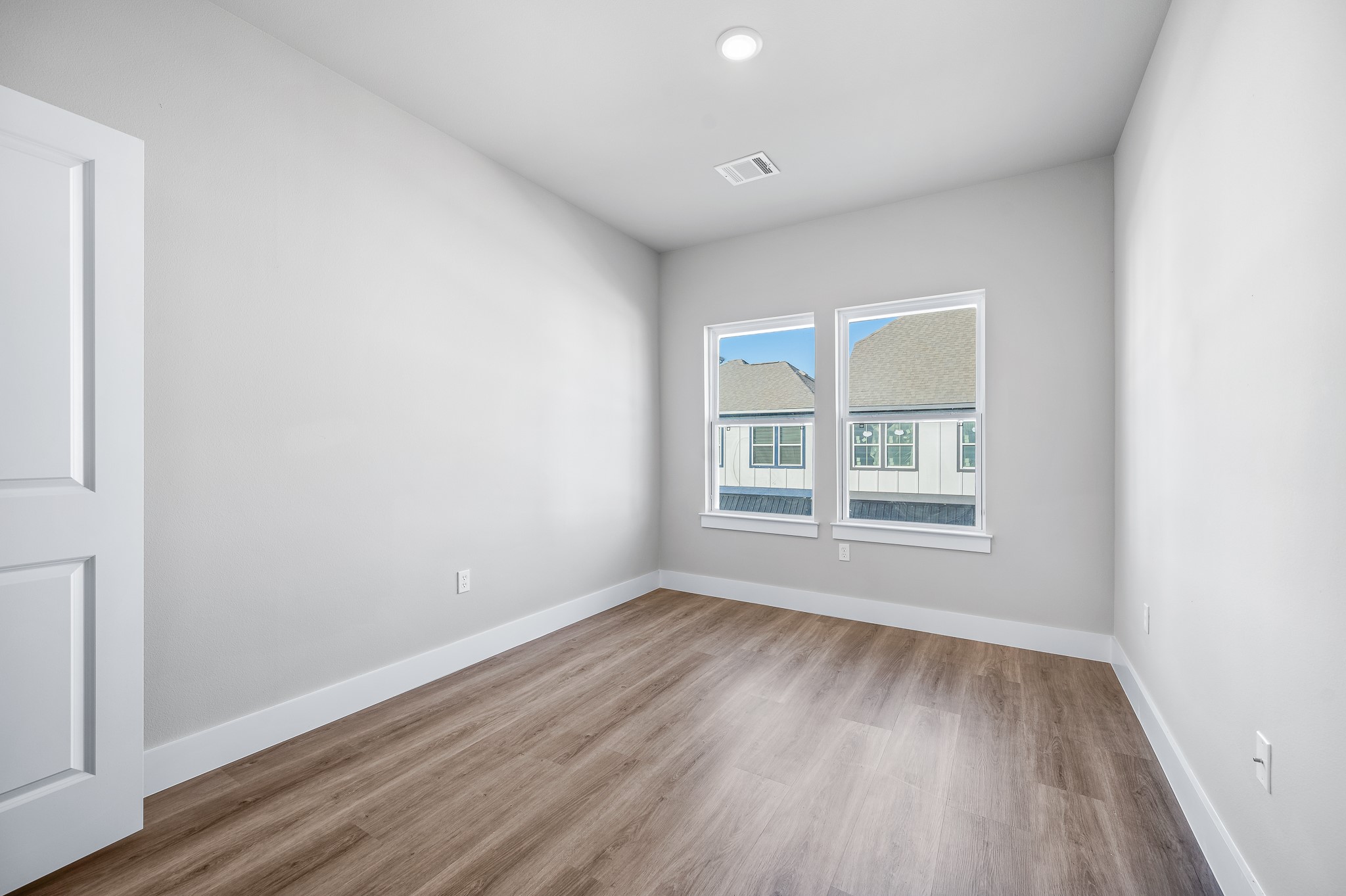 6702 Metro Boulevard, Unit 12 Houston, TX 77083 - Photo 30 of 48 an empty room with wooden floor and windows