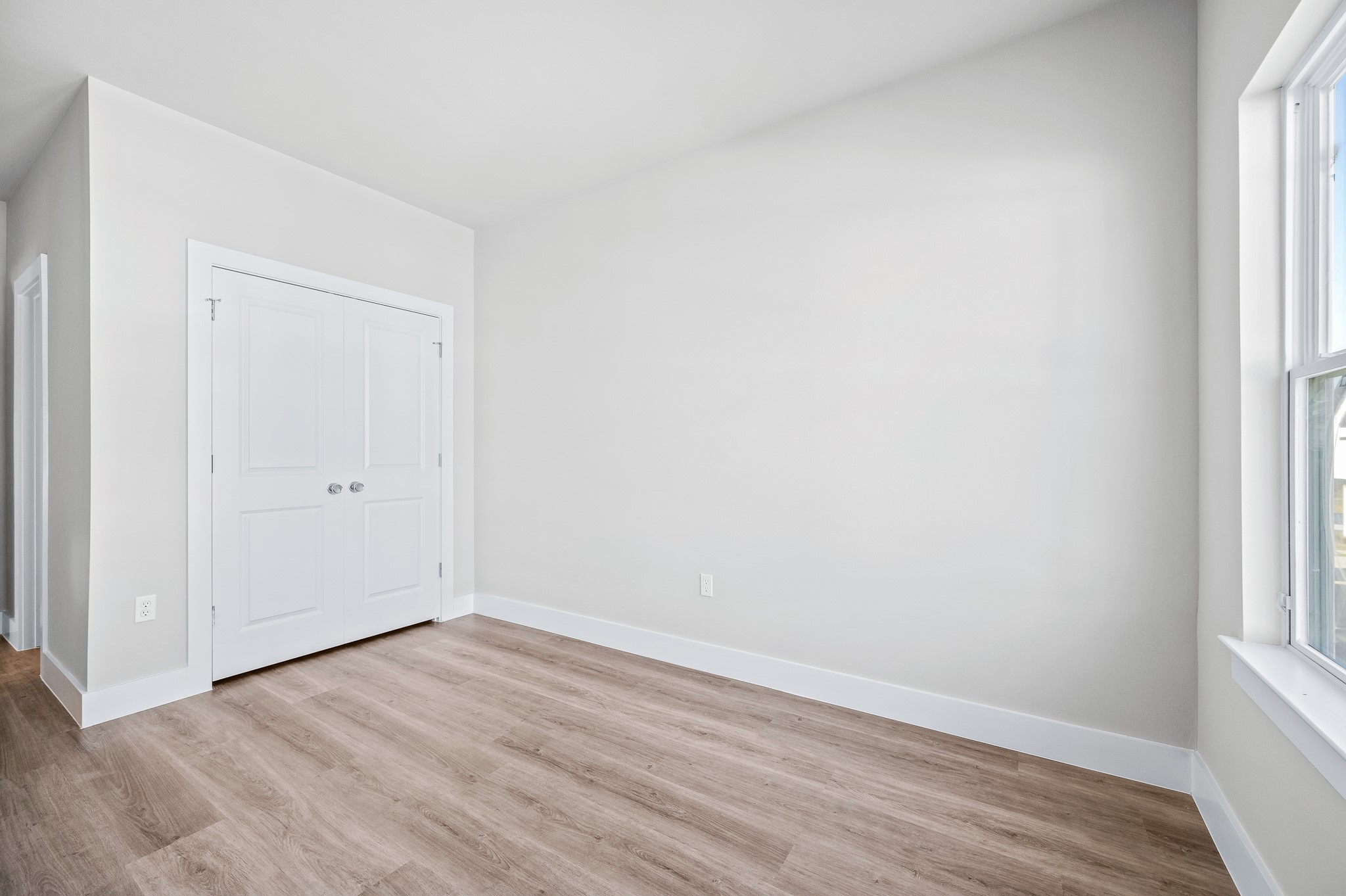 6702 Metro Boulevard, Unit 12 Houston, TX 77083 - Photo 33 of 48 a view of an empty room with wooden floor and a window