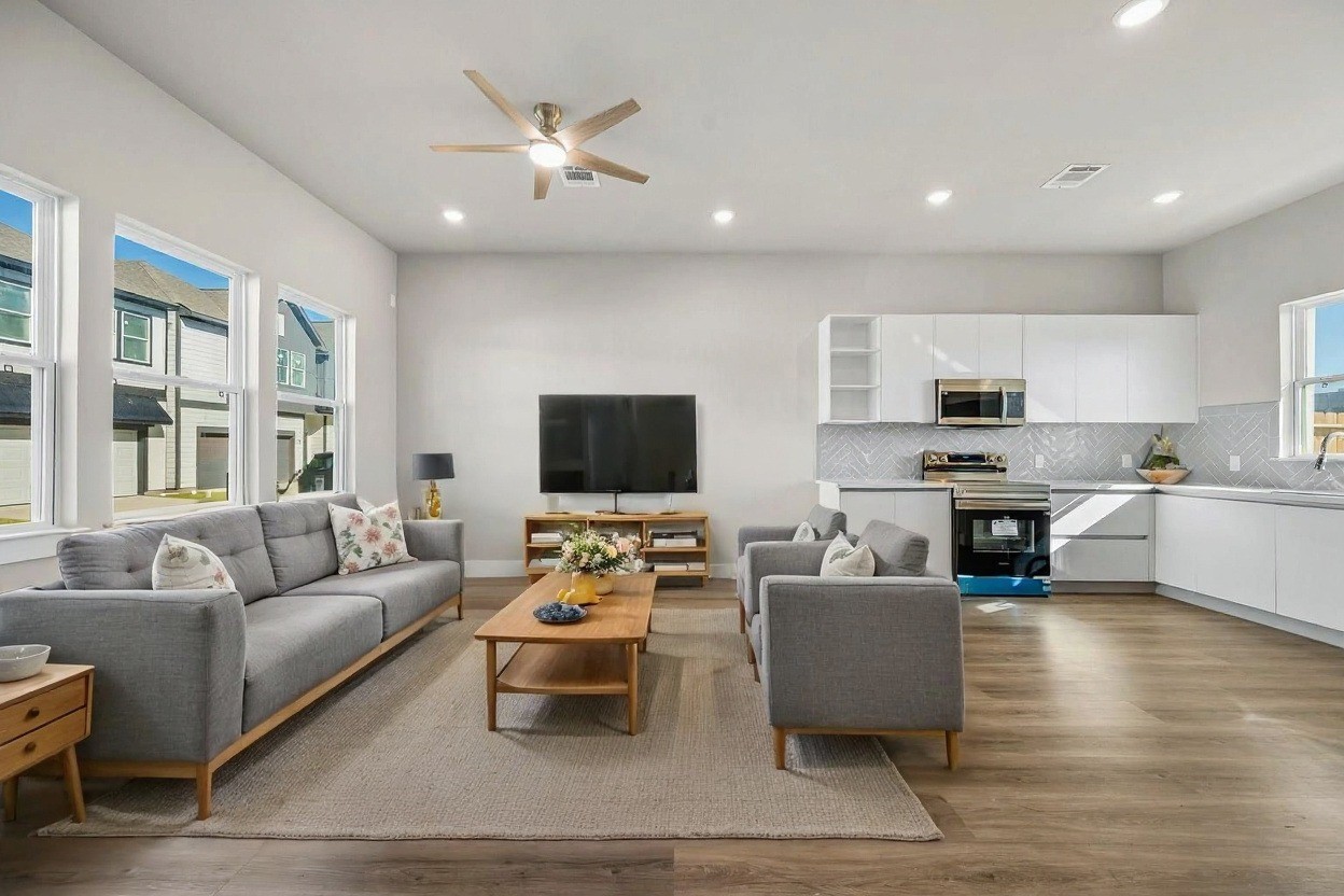 6702 Metro Boulevard, Unit 12 Houston, TX 77083 - Photo 7 of 48 a living room with furniture kitchen view and a flat screen tv