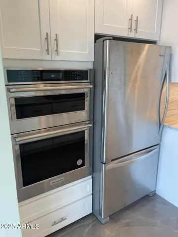 a living room with couches chairs and kitchen view with wooden floor
