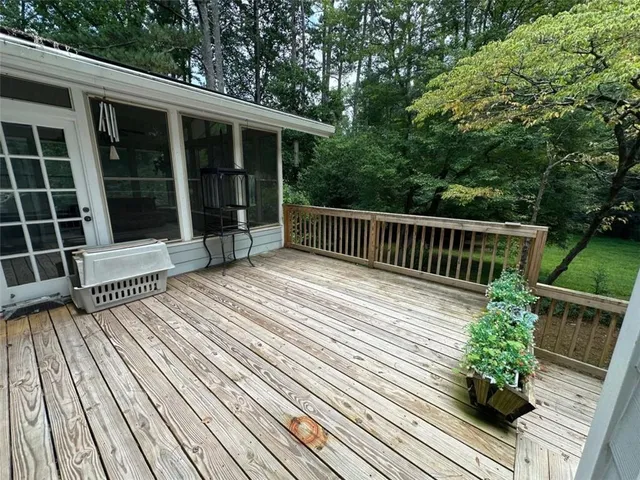 a balcony with wooden floor table and chairs