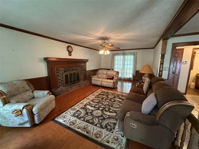 a living room with furniture a fireplace and a chandelier