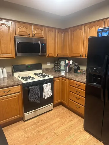 a kitchen with stainless steel appliances granite countertop a stove a refrigerator and a microwave