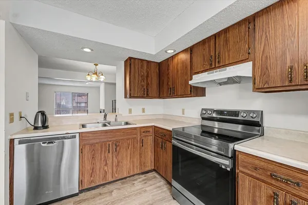 a kitchen with stainless steel appliances granite countertop a sink stove and cabinets