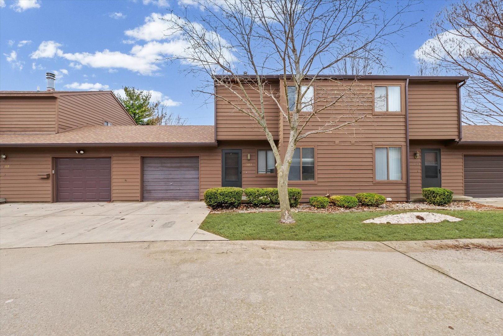 2111 Sunview Drive, Unit 2111 Champaign, IL 61821 - Photo 2 of 28 a front view of a house with a yard and garage
