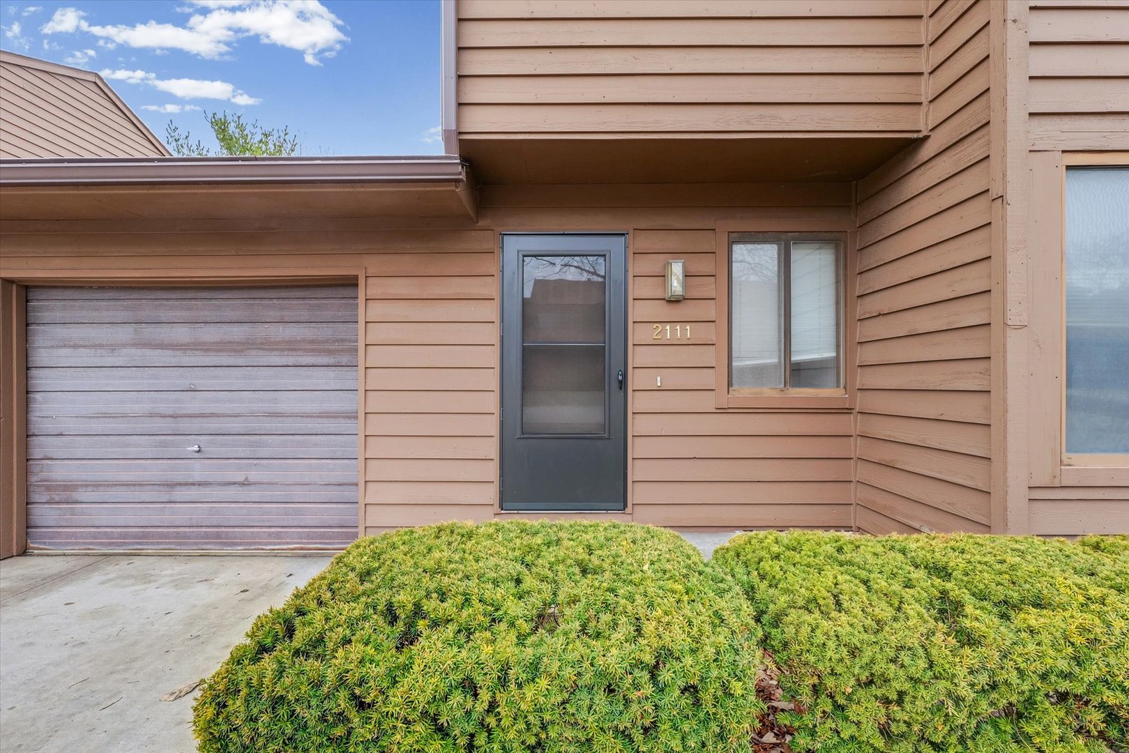 2111 Sunview Drive, Unit 2111 Champaign, IL 61821 - Photo 4 of 28 a front view of a house with a garden