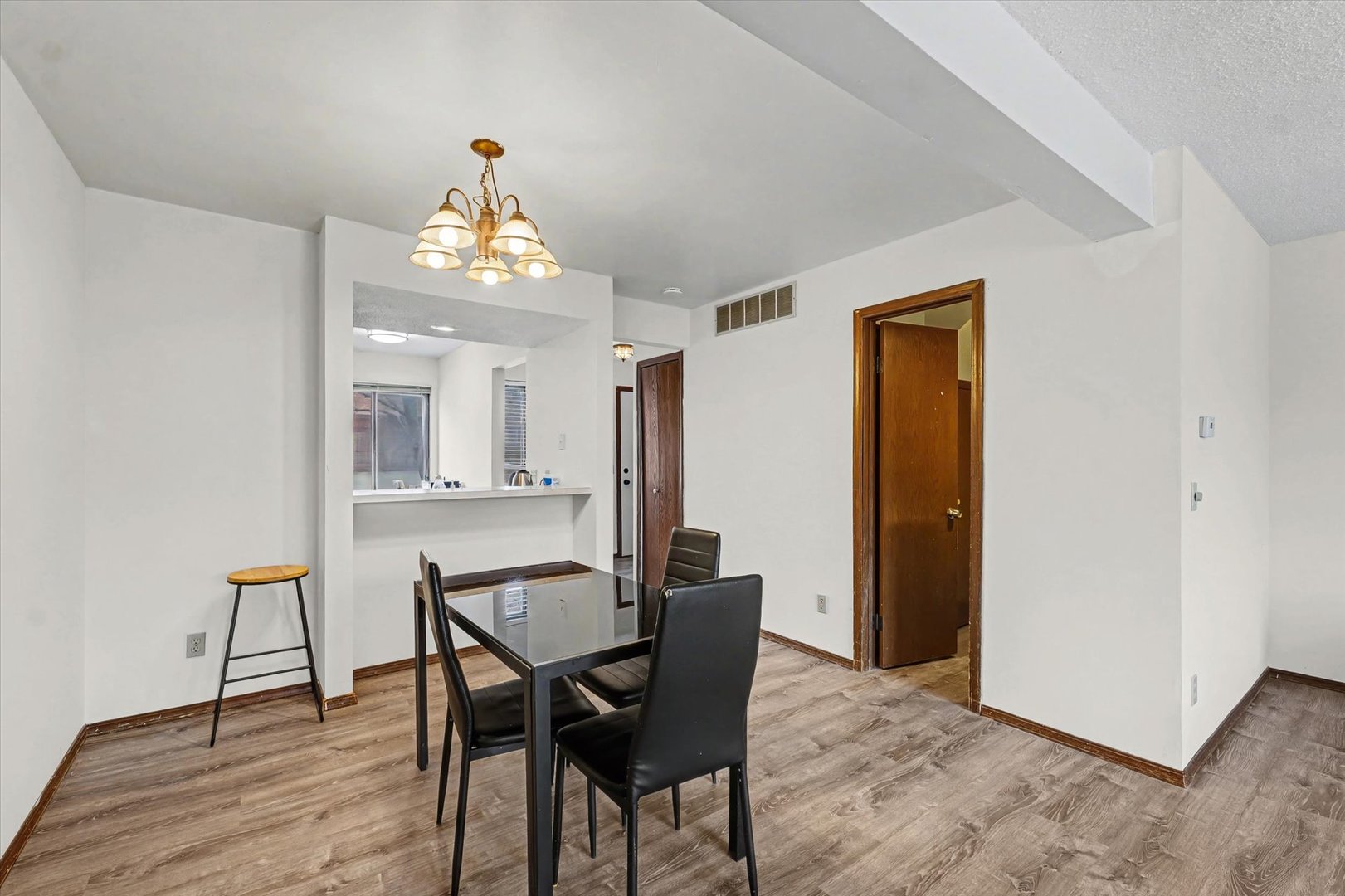 2111 Sunview Drive, Unit 2111 Champaign, IL 61821 - Photo 9 of 28 a dining room with wooden floor a chandelier a wooden table and chairs