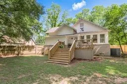 a front view of house with yard and trees in the background