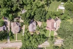 an aerial view of a house with a yard and large trees