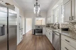a large kitchen with a lot of counter space a sink and stainless steel appliances