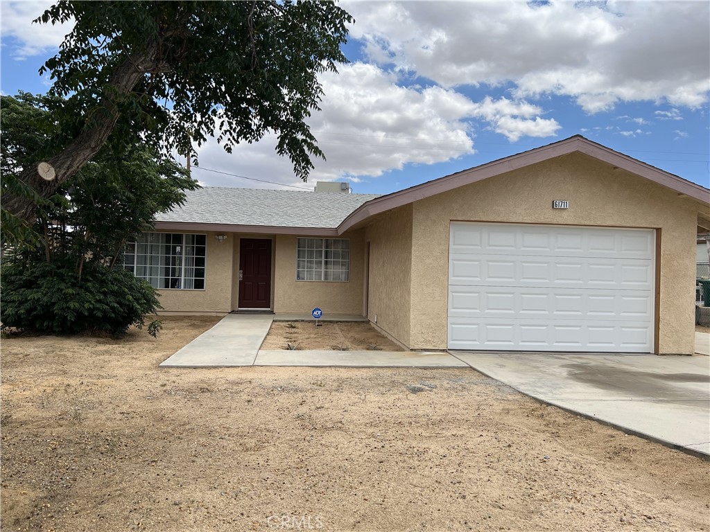 61711 Morningside Road Joshua Tree, CA 92252 - Photo 1 of 1 a front view of a house with a yard and garage