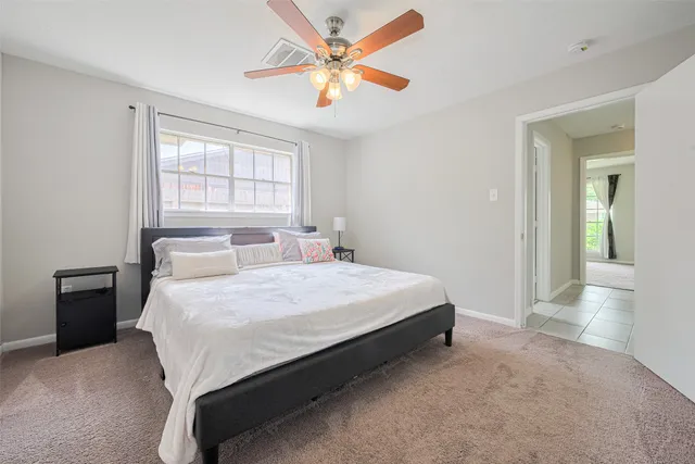 a bedroom with a bed and a large window