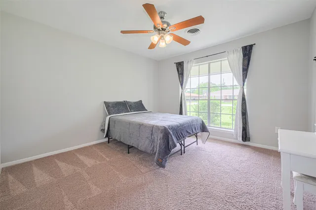 a spacious bedroom with a bed and a large window