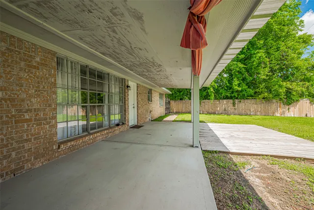 a view of a backyard with brick wall and plants
