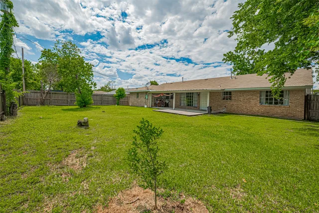 a view of a house with backyard and a tree
