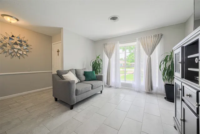 a living room with furniture a flat screen tv and a large window