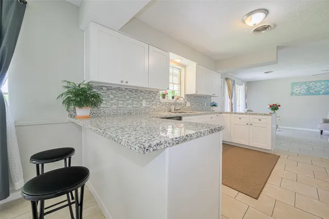 a kitchen with granite countertop a sink a stove a microwave and island