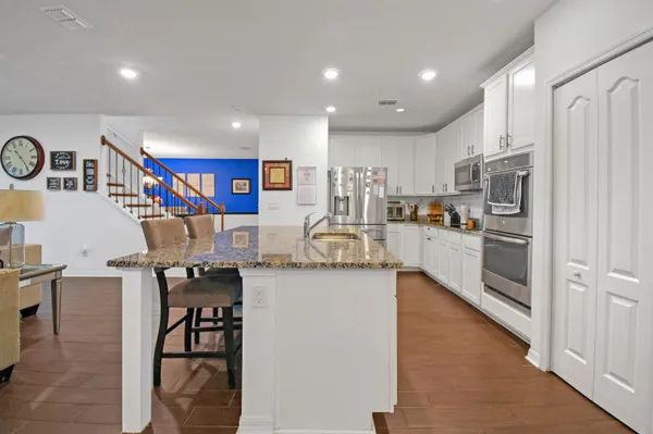 a kitchen with stainless steel appliances granite countertop a refrigerator and a stove top oven