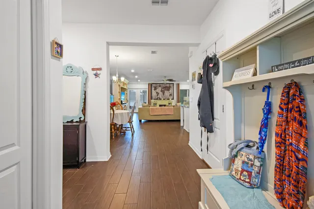 a view of a hallway with wooden floor and windows