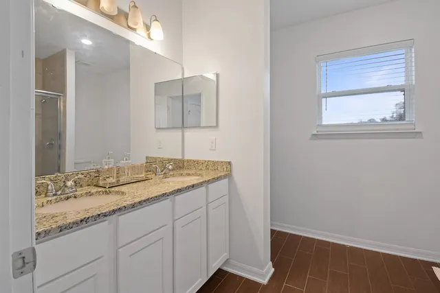 a bathroom with a granite countertop sink and a mirror