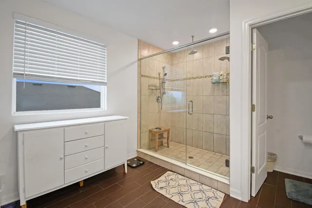 a bathroom with a shower a sink and a mirror