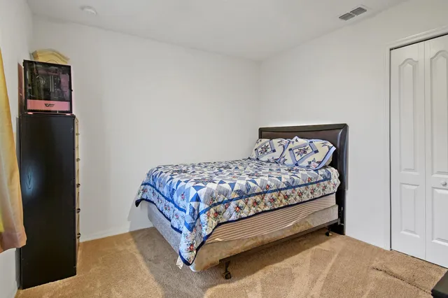 a bed sitting in a bedroom next to a bathroom