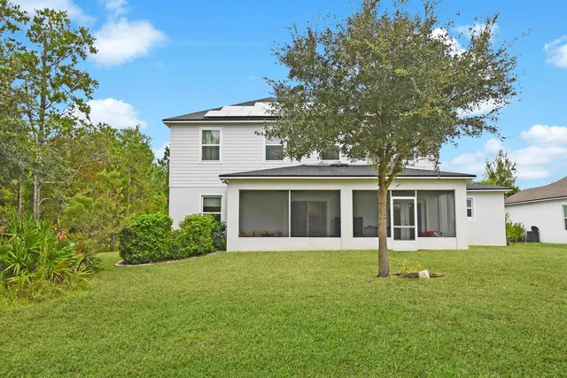 a front view of a house with a yard and trees