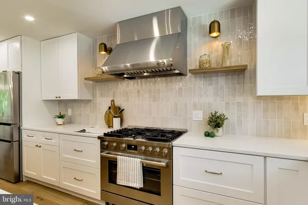 a kitchen with stainless steel appliances granite countertop white cabinets and a stove
