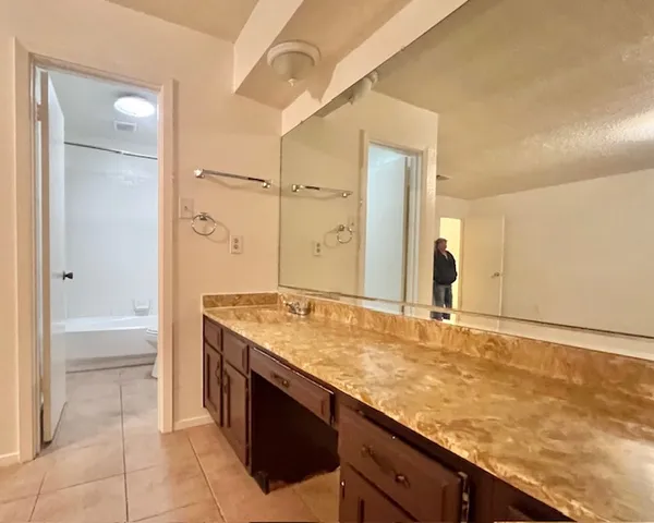 a bathroom with a granite countertop sink and a mirror