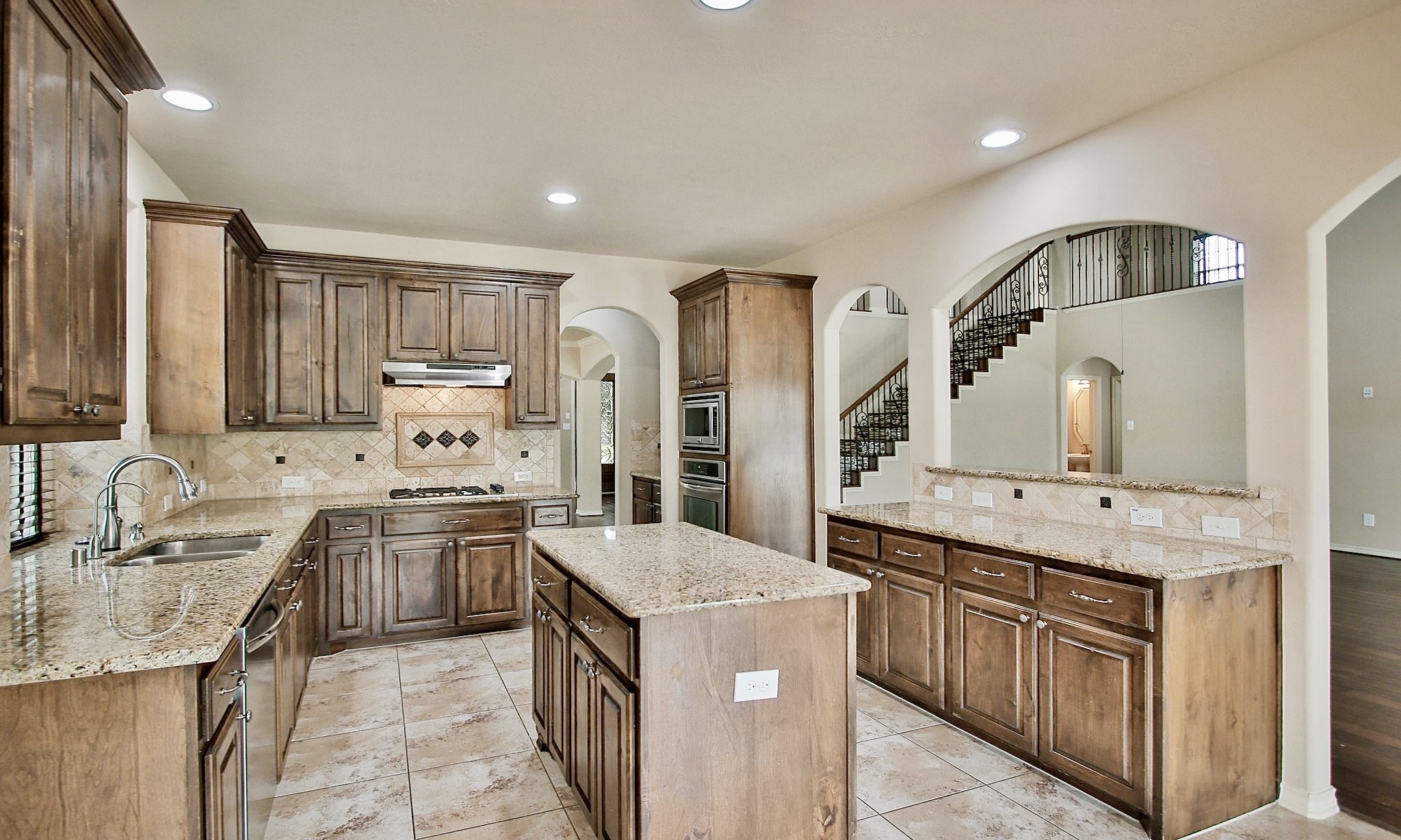 19818 Iceland Court Spring, TX 77379 - Photo 11 of 35 a kitchen with stainless steel appliances granite countertop a sink stove and refrigerator