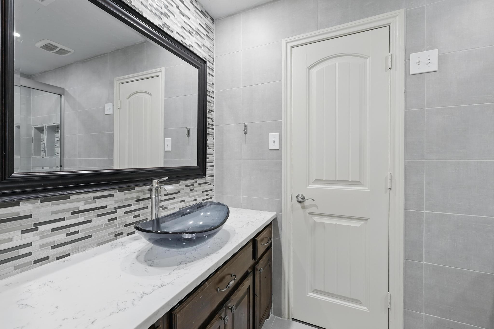19818 Iceland Court Spring, TX 77379 - Photo 25 of 35 a bathroom with a granite countertop sink and a mirror